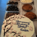 Cherry blossom cake on white cake stand with piped pink petals