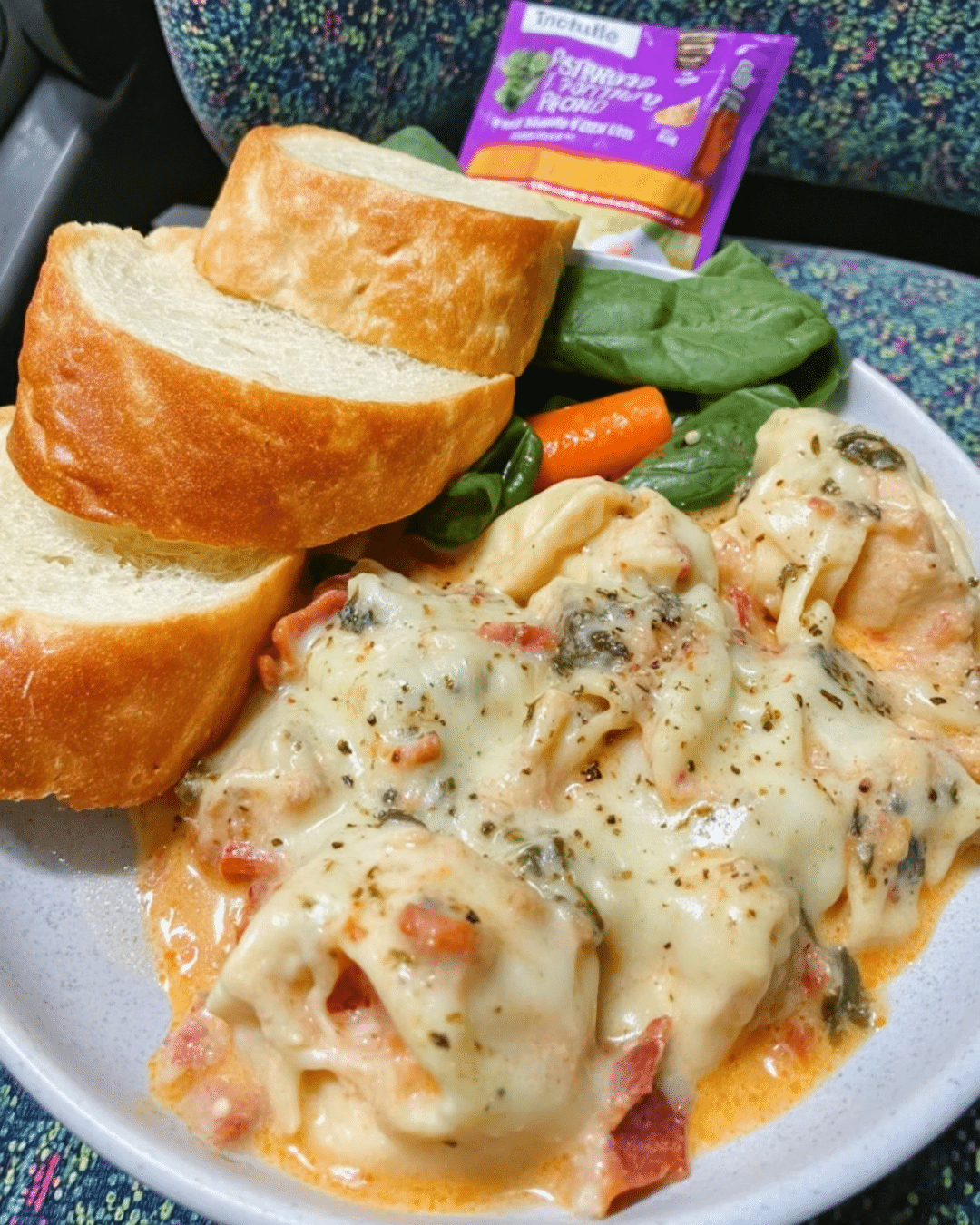 Overhead of creamy chicken soup with pasta and spinach