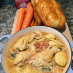 Creamy chicken and spinach soup in white ceramic bowl