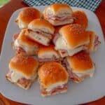 Ham and Cheese Sliders: Easy appetizer recipe perfect for game day, parties, or a quick dinner. These delicious sliders are made with Hawaiian rolls, ham, Swiss cheese, and a savory butter sauce. Get the recipe for this crowd-pleasing finger food!