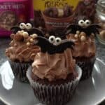Halloween Oreo bat cupcakes on rustic wood table - Halloween Food Ideas for Parties