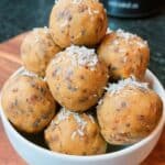 Pumpkin protein balls on parchment paper with cinnamon dust