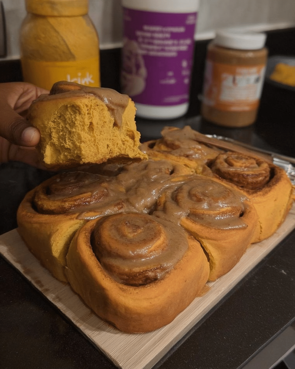 Pumpkin spice cinnamon rolls with creamy chai glaze on plate
