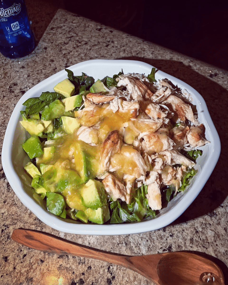 A colorful avocado and mango salad in a white bowl, garnished with cilantro.