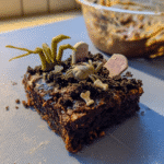 Graveyard Brownies served on a platter with a scoop of ice cream.
