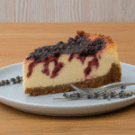 A slice of Ravenclaw Midnight Blueberry Cheesecake on a plate with a fork.